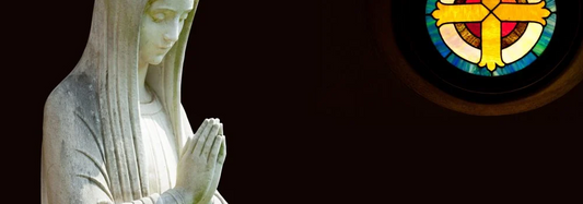 A close-up of a statue of a saint with hands folded in prayer, symbolizing the veneration of saints in Catholicism without worship.